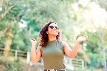 Happy woman smiling and having fun, wearing sunglasses in a public square.