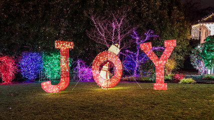 Portland, Oregon \ USA - December 27 2019: Colorful light installation art  - word "Joy" at a Miracle of a Million Lights  exhibit at  Victorian Belle historic landmark