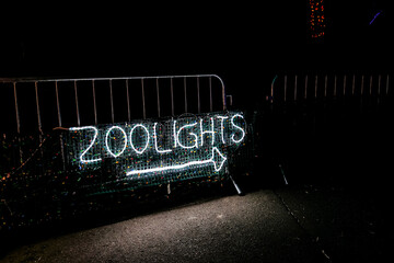 Portland, Oregon / USA - December 28, 2019:  Sign made of the light strip on a metal portable fence read "ZOOLIGHTS" with an arrow under it