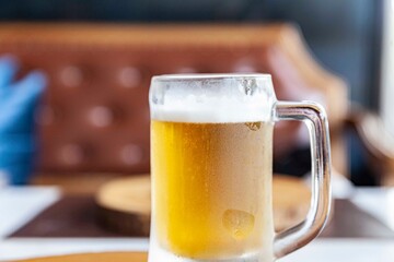 A large beer mug is placed on the counter table inside the bar.