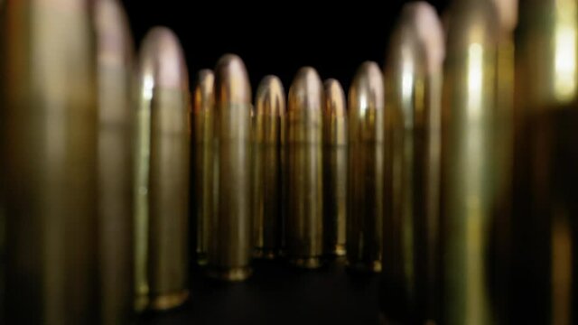 DOLLY SHOT, PULLING BACK THROUGH A CACHE OF RIFLE BULLETS.  4K, WIDE ANGLE MACRO.  NO PEOPLE.