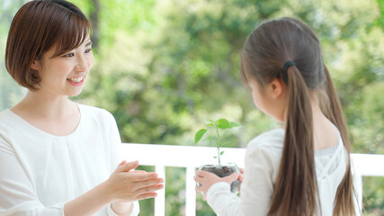 観葉植物を持つ娘と母