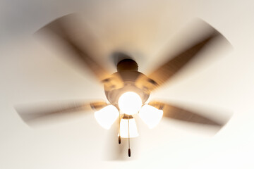 Residential ceiling fan in motion on a white ceiling. - obrazy, fototapety, plakaty
