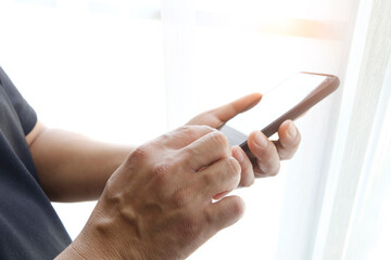 man hand holding smart phone at office