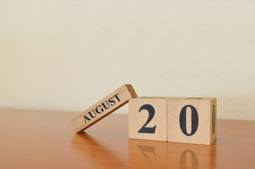 August 20, Date design with calendar cube on wooden table and white background.