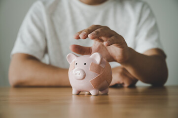 Man hand holding piggy bank on wooden table. Concept of save money and finance business investment