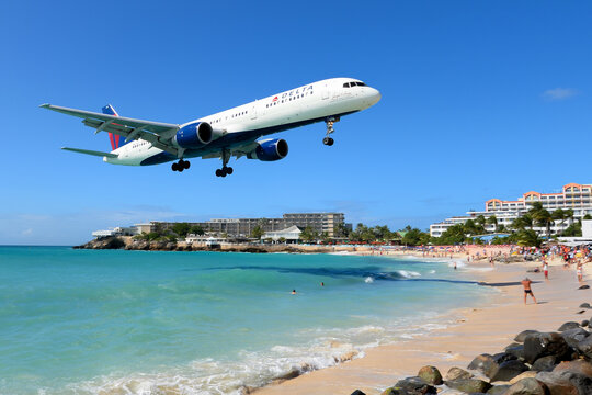 Delta Airlines Boeing 757 about to land in St Maarten airport passing over Maho Beach, famous for the airplanes passing very low. Tourist attraction.