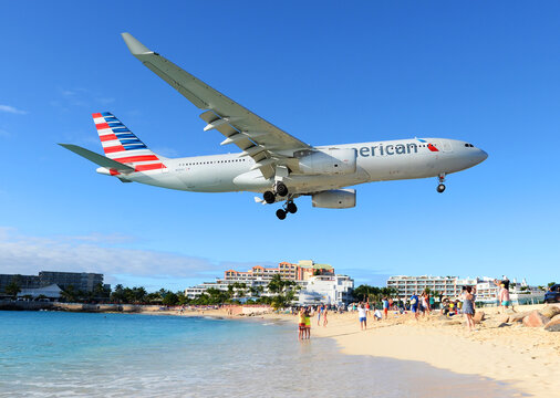 American Airlines Airbus A330 about to land in SXM airport over touristic Maho Beach in Saint Maarten, Dutch Antilles. Airport beach in St. Maarten
