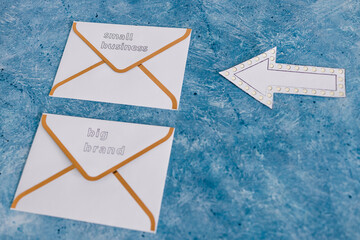 small business vs big brand texts over newsletter email envelopes with arrow pointing towards the...