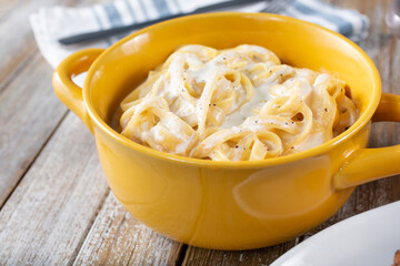 A closeup view of a bowl of fettuccine Alfredo.