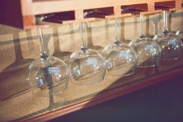 A view of several hanging wine glasses as decoration in a restaurant setting.