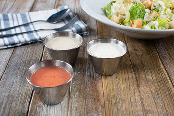 A view of a variety of salad dressings in condiment cups.