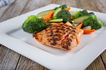 A view of a plate of grilled salmon and steamed vegetables.