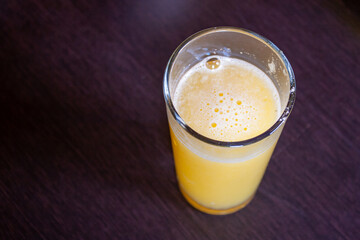 vaso con jugo de naranja sobre fondo negro