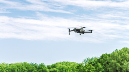 drone with high resolution photo camera flying over summer forest