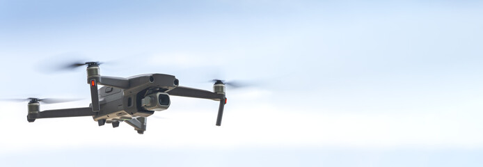 small drone with high resolution camera hovering in air for aerial photography - obrazy, fototapety, plakaty