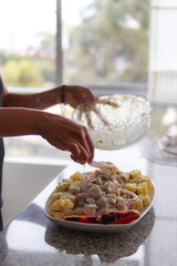 Plato de ceviche acompañado de una botella de vino y tres copas sobre una mesa