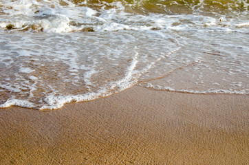 Waves hitting sand shore on a late evening. Photo taken in Asia, Thailand