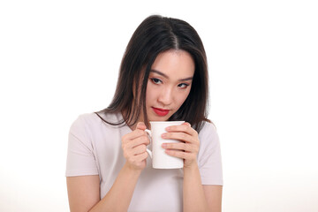 Beautiful young south east Asian woman holding white coffee tea cup emotion expression on white background look down