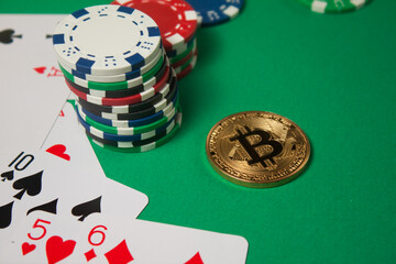 Classic playing cards, chips, red dice, bitcoin and dollars on green background.