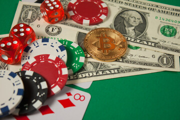 Classic playing cards, chips, red dice, bitcoin and dollars on green background.