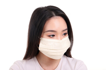 Beautiful young south east Asian woman wearing yellow off white three ply anti virus surgical face mask on white background look left