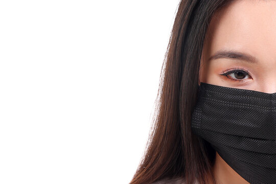Beautiful young south east Asian woman wearing black three ply anti virus surgical face mask on white background