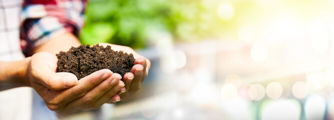 Woman's hands holding abundance soil for agriculture or planting concept.