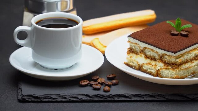 Portion of Traditional Italian Tiramisu dessert, cup of espresso, mocha and coffee beans