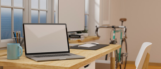 Laptop with mock-up screen on wooden worktable beside the window  in the room with bicycle, 3D rendering