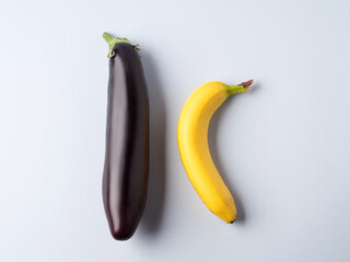 Eggplant and banana on gray background. Couple concept