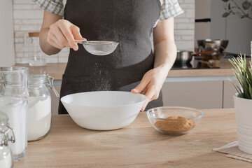 The process of making gluten-free baked goods.  Rice flour is sieved through a sieve.