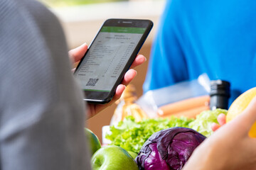 Customer checking grocery that ordered online and delivered by deliveryman at home, food delivery service concept