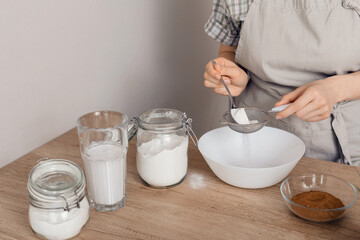 The process of making gluten-free baked goods.  Rice flour is sieved through a sieve. The concept of cooking vegetarian pastries.