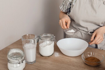 The process of making gluten-free baked goods.  Rice flour is sieved through a sieve. The concept of cooking vegetarian pastries.