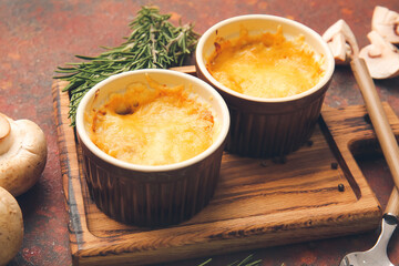 Ramekins with tasty julienne and ingredients on grunge background, closeup