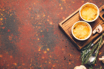 Ramekins with tasty julienne and ingredients on grunge background