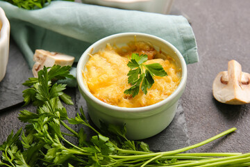 Ramekin with tasty julienne and ingredients on dark background, closeup