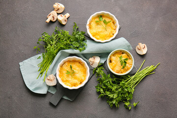 Ramekins with tasty julienne and ingredients on dark background