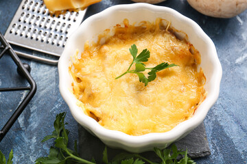 Ramekin with tasty julienne and ingredients on color background, closeup