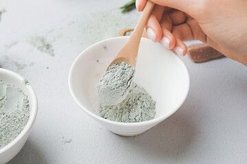 Woman preparing facial mask on grey background, closeup