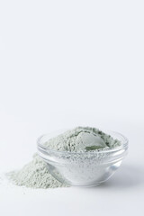 Bowl with cosmetic clay on white background