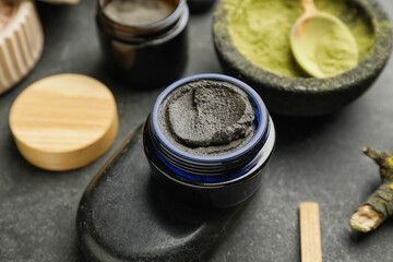 Jar of cosmetic clay on dark background, closeup
