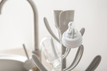 Drying rack for baby bottles on table near sink, closeup
