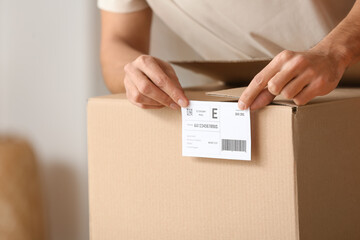 Young man with parcel box at home, closeup