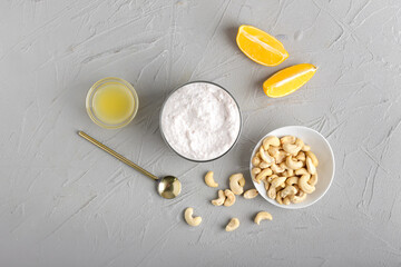 Bowl of sour cream with cashew nuts on light background