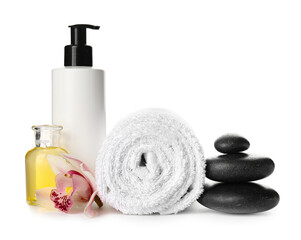 Composition with cosmetic products, towel and spa stones on white background