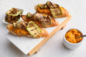 Tasty bruschettas with squash on light background