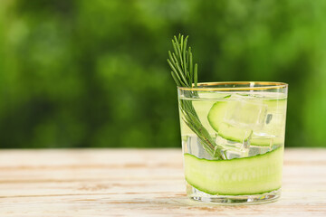 Glass of cucumber lemonade on table outdoors