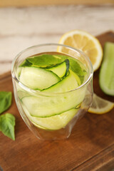 Glass with cucumber lemonade on wooden background